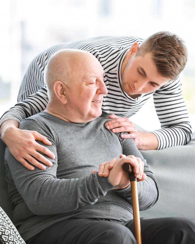 Male caregiver with senior man in nursing home