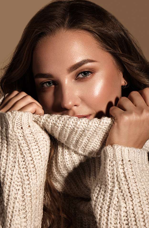 Beautiful young girl with gentle make-up in warm sweater