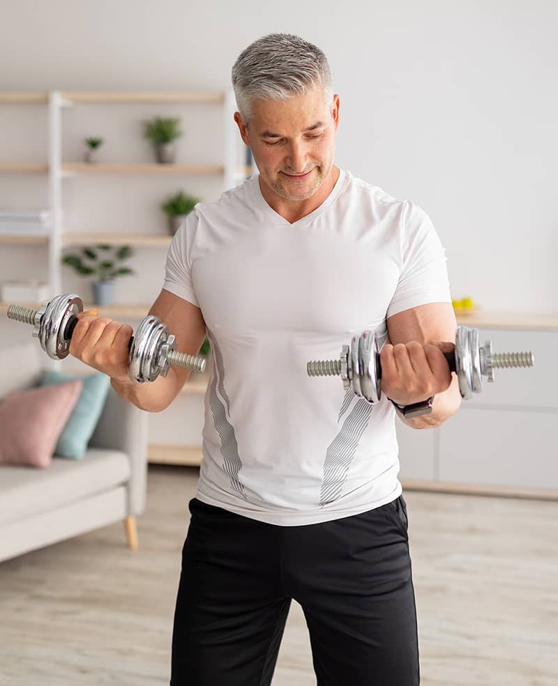 Athletic middle-aged man doing dumbbell 