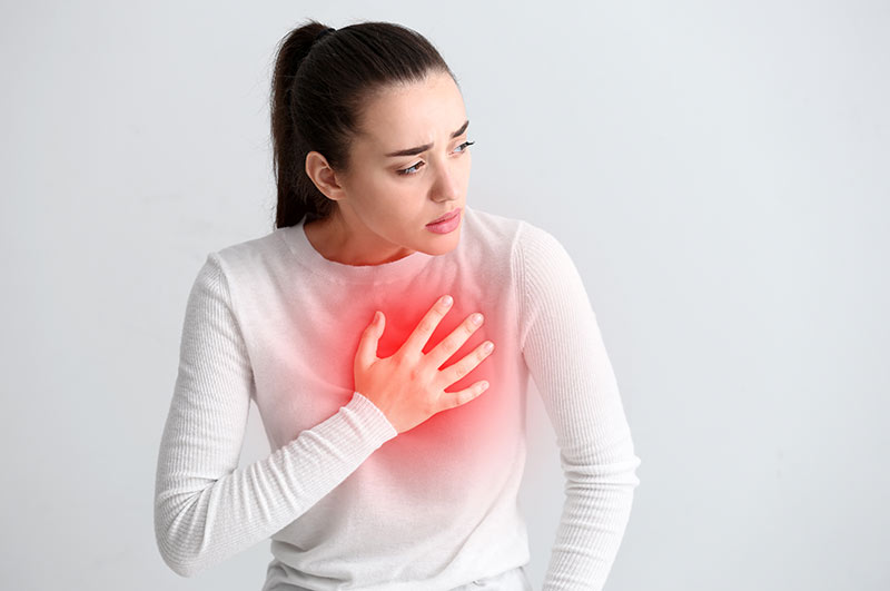 Woman holding her chest in pain.